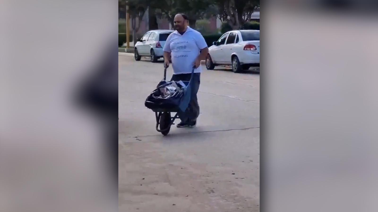 商人推着一辆装满钱的独轮车来交电费